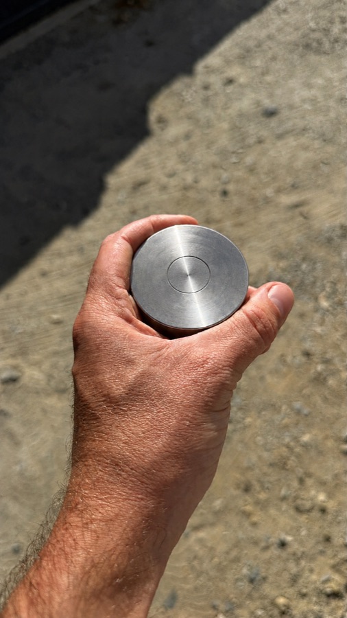 Un palet d'acier tenu en main, pour donner l'échelle